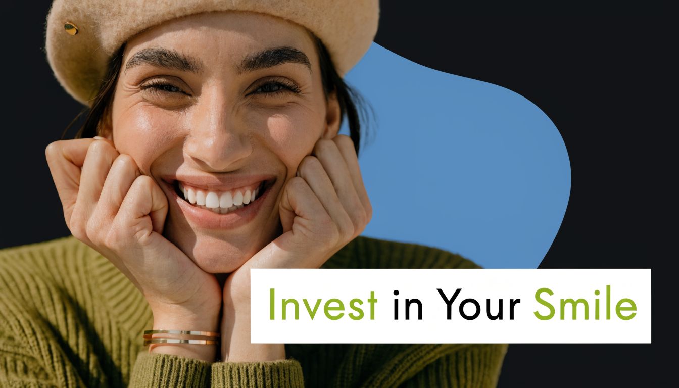 A smiling woman wearing a beige beret and olive green sweater posing with her hands on her chin.