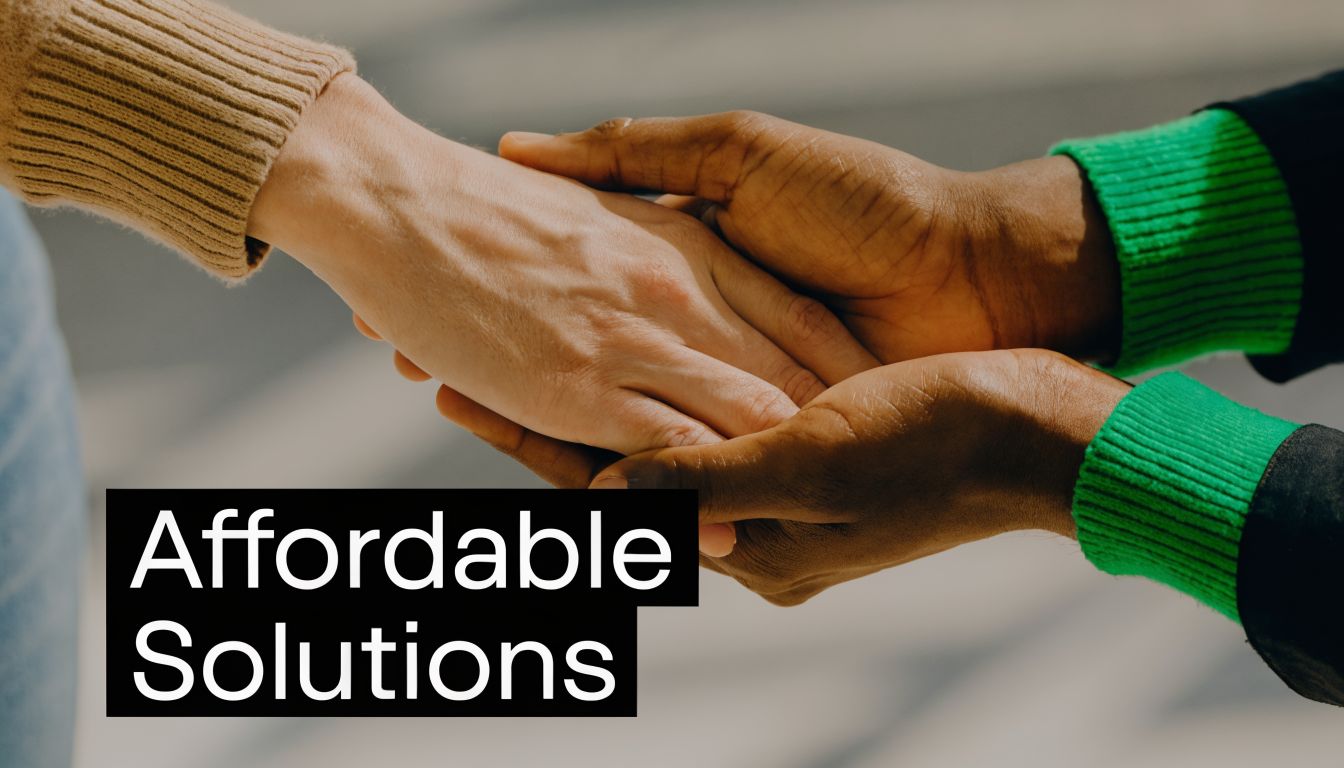 A close-up view of two people holding hands, showing a gesture of comfort, support, and professional care.