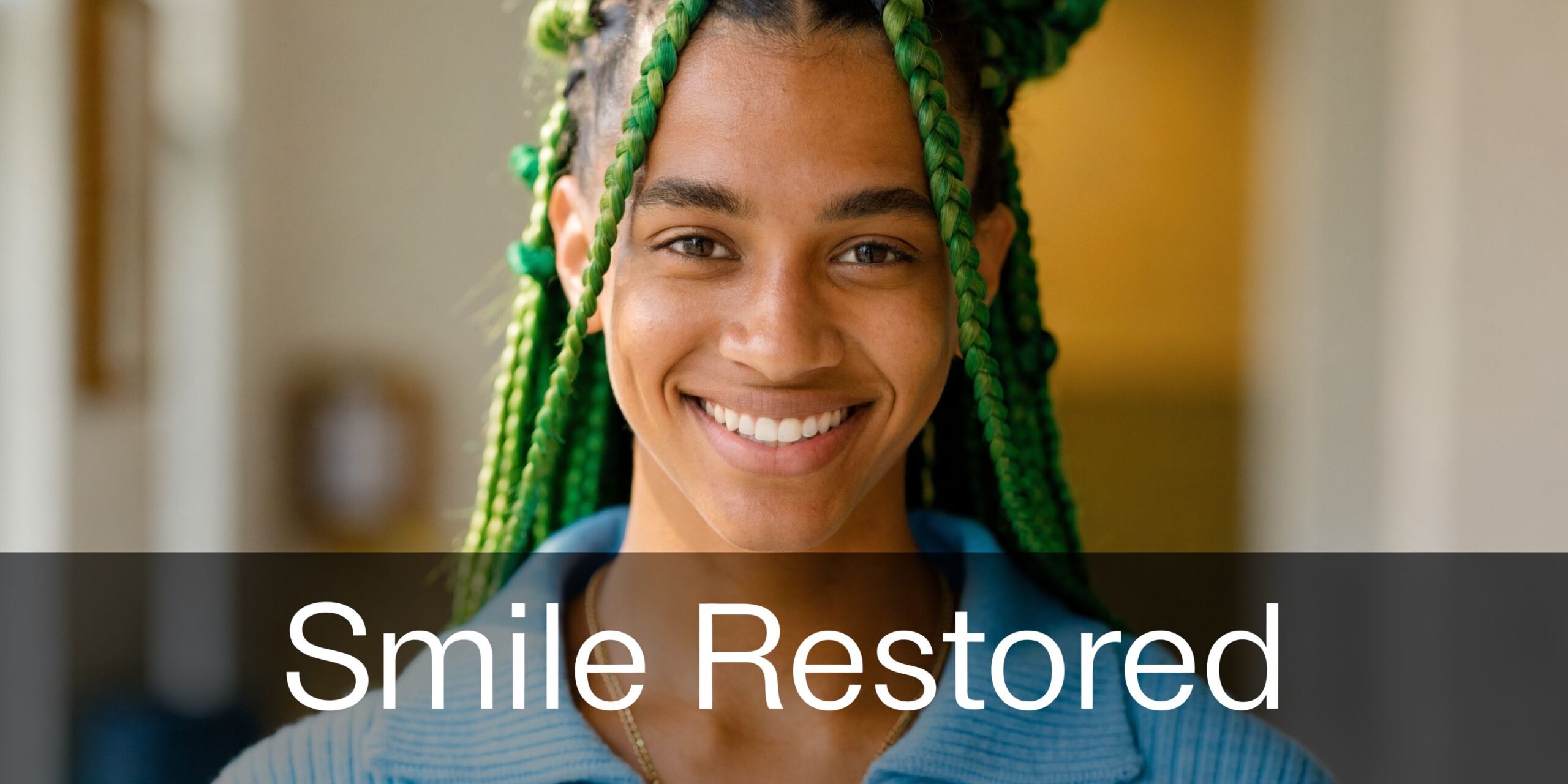 A smiling young woman with bright green braided hair, representing the confidence gained through restored dental health.