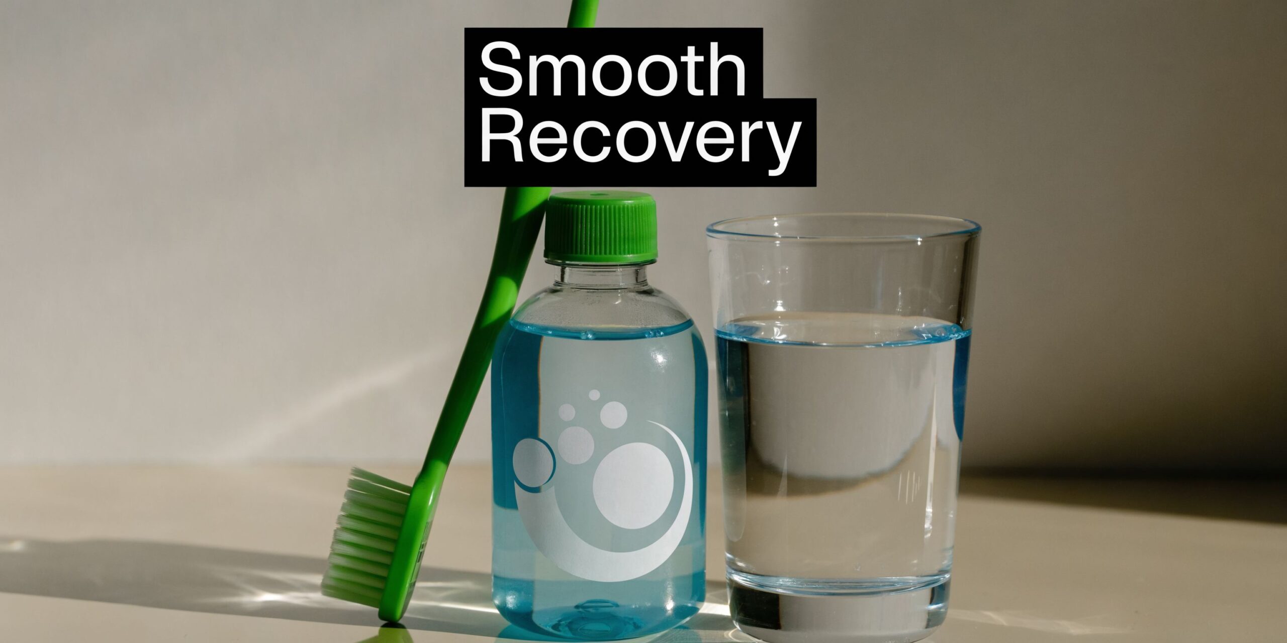 A green toothbrush stands next to a bottle of blue mouthwash and a glass of water.