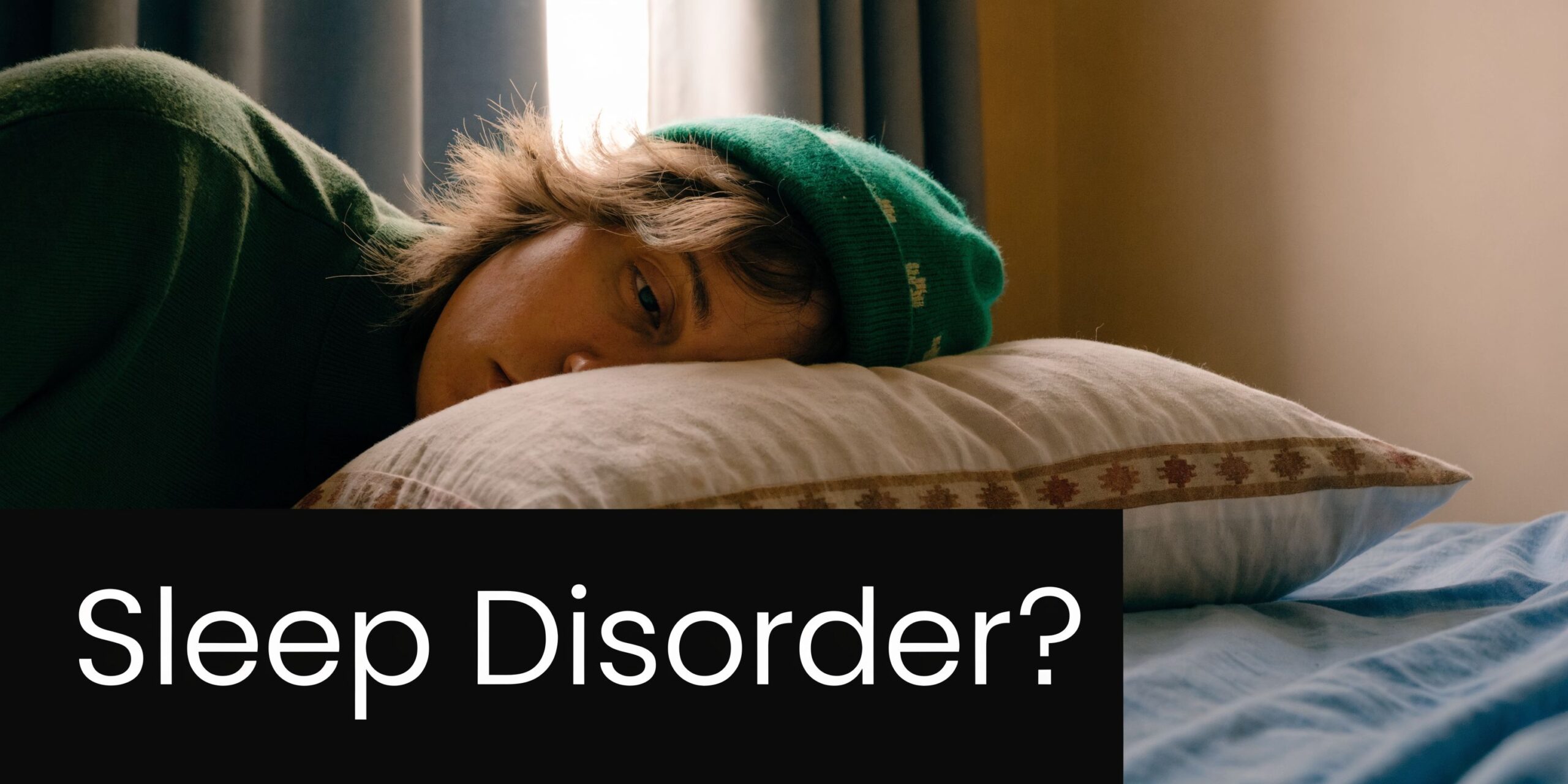 A person lying on a pillow in bed looking tired while dealing with a sleep disorder.