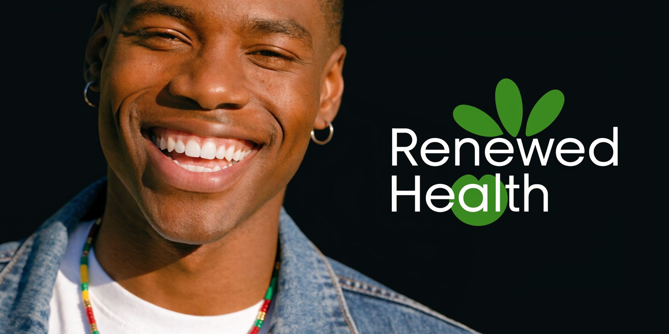 A close up portrait of a smiling young man with healthy teeth next to the Renewed Health logo.
