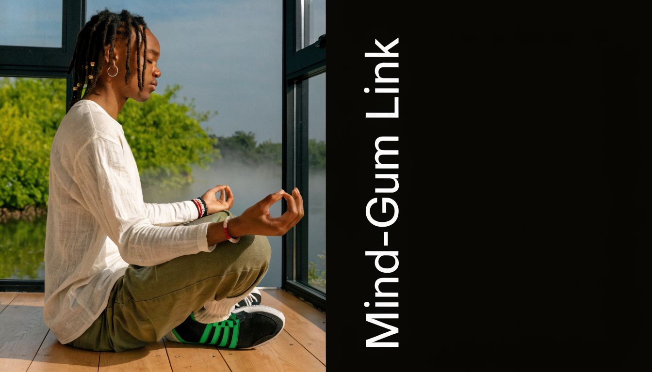 A person with dreadlocks sitting in a meditative pose next to a window overlooking a misty landscape.